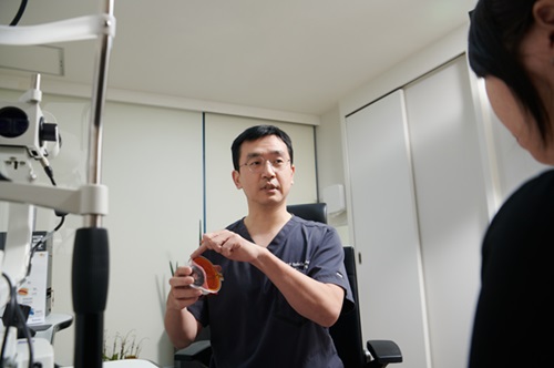 Dr. TaeWan Kim, a retina and cataract treatment specialist, is seen attending to a patient. When necessary, each medical professional collaborates organically with other specialists to provide integrated care.
